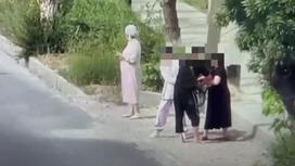 У женщины пытаются отобрать сумку