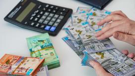 Женщина кладет деньги на стол